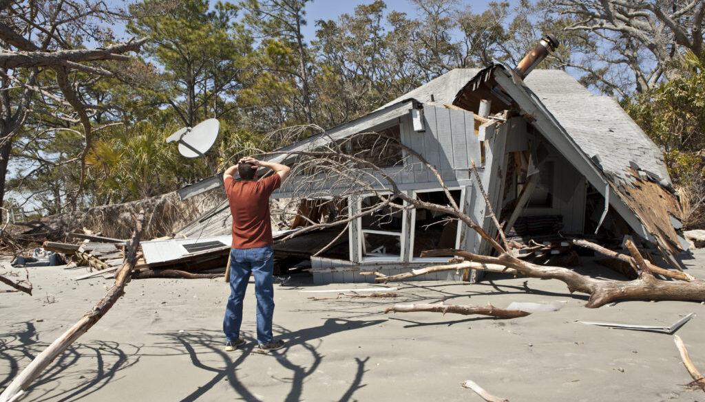 man grieving over destroyed house